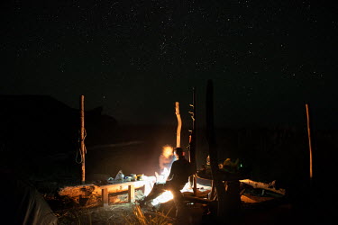 Roman Shatrov sits beneath the stars beside a camp fire. Shatrov mobilised a group of like-minded friends to claim 29 hectares from a land distribution scheme in the Bay of Silence to create a private...
