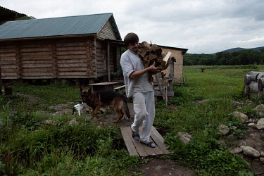 Dmitryi, a worker at a traditional bakery, carries wood for the oven. The bakery was created by Andrey, a businessman who returned to Russia after a life in the United States to take advantage of a fr...