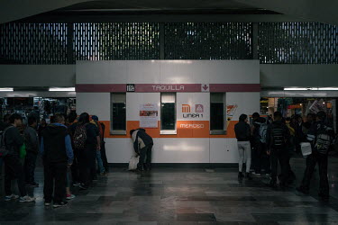 Male passengers queue at a ticket booth where the windows remain empty as female workers strike during the national women's strike 'A Day Without Women', many passengers had to buy a rechargeable card...