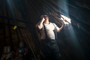 Eyko, a Nenets activist, talks on a mobile phone inside his tent ('chum'). He created an internet media site called 'Golos Tundri' (Voice of the Tundra) that seeks to unite herders, fight for their ri...
