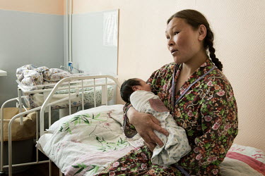 Larisa, who lives out on the Tundra, with her new born child at the town's maternity hospital. If a woman has health complications and cannot get to the hospital on her own, a medical helicopter fligh...