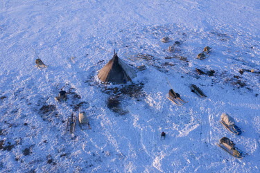 An indigenous Nenet's camp with a tent ('chum') in the centre surrounded by sledges.