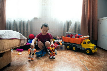 A Nenets child, who's father lives and works out on the tundra, plays with toys in an apartment in Panaevsk. The boy lives in the town with his mother. The family live on the tundra in summer.