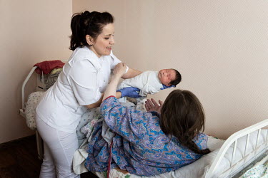 Medical worker Tatyana hands a new born child to its mother, a Nenet woman who has travelled from the Tundra to give birth at the town's maternity hospital. If a woman has health complications and can...