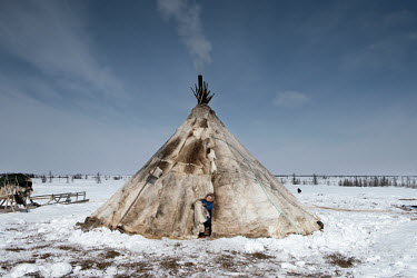Gosha, a Nenets child, leaves a reindeer skin tent ('chum').
