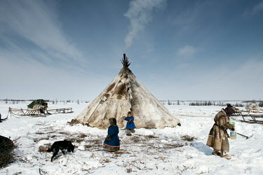 A family outside their reindeer skin tent ('chum').