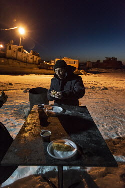 A man eats at a cafe on the 'zimnik' winter road that runs on the frozen Ob River connecting small villages with Salekhard, the administrative centre of Yamal.
