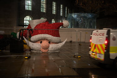 The head of a giant Santa, part of municiple Christmas decorations, stands in a fenced off area in front of the Central Library in St Peter's Square on a rainy Saturday evening towards the end of the...