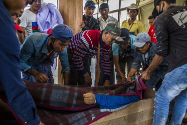 Friends and relatives place a man into a coffin at the hospital morgue in Hpakant. The man, who worked at a jade mine, died in a disaster at the mining site in Hmaw Warn Lay. The collapse of a huge la...