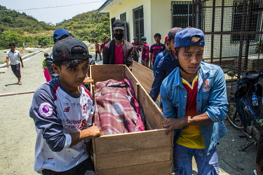 Friends and relatives carry a coffin, at the hospital morgue in Hpakant, containing a man who died in a disaster at a jade mining site. The collapse of a huge lake of sludge killed at least 55 workers...