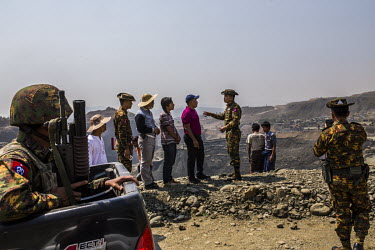 The military commander of the division in Hpakant, along with company representatives, inspects the aftermath of a disaster at a jade mining site where the collapse of a huge lake of sludge killed at...