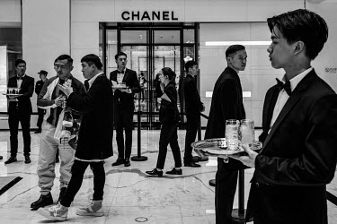 Waiters serve champagne at a private event put on by a luxury brand at a mall in downtown Beijing.