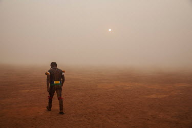 An indigenous man walks through the village of Yawalapiti amidst the smoke from bush fires in the Xingu Indigenous Park. With rising temperatures, caused by climate change, the number of forest fires...