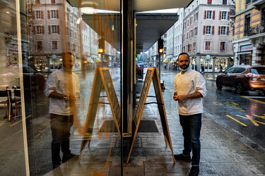 Ash stands in the street outside of his restaurant, Le Dhaba, in the Paquis district. During Geneva's second lockdown restaurants have been permitted to stay open, but only for take away service. He h...