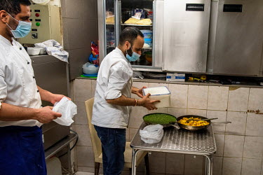 Ash preparing take away meals in the kitchen of his restaurant, Le Dhaba, during Geneva's second lockdown in which restaurants have been permitted to stay open, but only for take away service. He has...