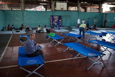 Community elder Gervasio Lopez, 83, sits on a camp bed as families from La Trinidad are settled in Escuintla city's gym after being evacuated from their community. Originally from Huehuetenango, hundr...
