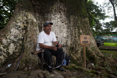 War survivor Bernanrdo Cruz, 51, stands guard under the Ceiba tree that serves as the community centre in La Trinidad. While most of the 235 families remain in shelters after the 3 June 2018 eruption...