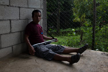 Joel Montejo, 45, member of the community security committee of La Trinidad, takes cover from the rain during a security round. While most of the 235 families remain in shelters after the 3 June 2018...