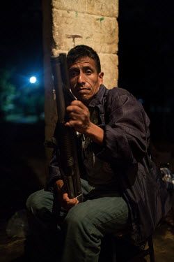 Celestino Montejo, 43, member of the community security committee of La Trinidad, takes a break from doing security rounds in the main outpost. While most of the 235 families remain in shelters after...