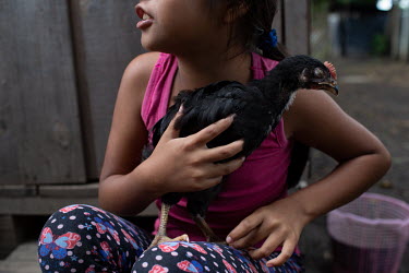 Saylin Camposeco, 8, holds her pet hen, who she hasn't named yet, outside her unit at the Single-Family Transitional Shelters.
