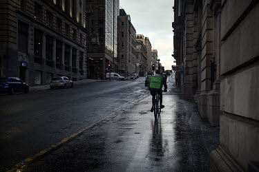 A take away delivery man cycles through the streets of central Glasgow which are in the Central Belt of Scotland, and are feeling the effects of government imposed lockdown restrictions during the cor...