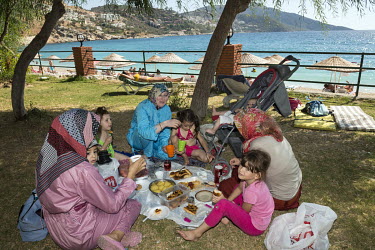 Women and children picnic in a park on the Mediterranean coast.
