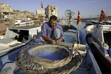 A fisherman check his nets on his boat moored in the port of Yumurtalik, a fishing town on the Mediterranean coast.
