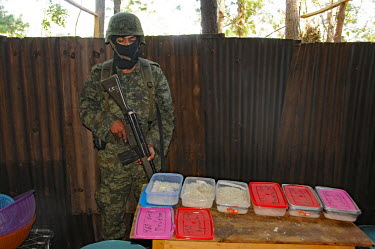 A soldier guards boxes of crystal meth (methamfetaimne) manufactured at a remote lab that was soon to be burned down by the army following a raid that first took place a few days earlier.