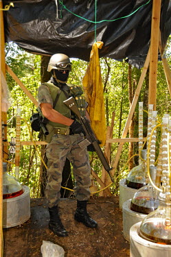 Soldiers guard chemicals and laboratory equipment at a remote crystal meth (methamfetaimne) lab which the army are to burn down a few days after it was first raided.