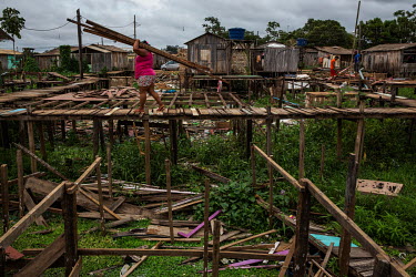 A resident of one of Altamira's stilt houses, who was forced to relocate because of the construction of Belo Monte dam, dismantles a house to reuse the material to build a new home or to expand the fo...
