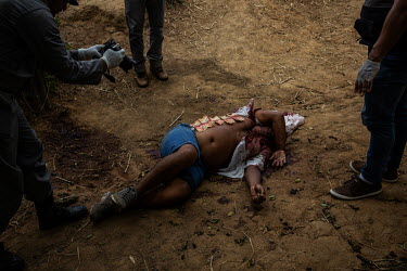 Police officers examine a body of a man killed in rural Altamira. In 2017 the Atlas of Violence published annually by Brazil's Institute of Applied Economic Research (IPEA), ranked Altamira as Brazil'...