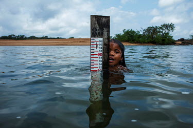 A Juruna child plays next to the depth measuring rod used by the indigenous people of the Miratu village to measure the flow of water from the Xingu River downstream of the Belo Monte hydroelectric da...