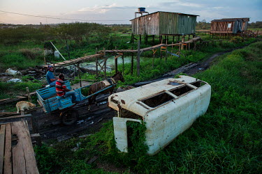 A horse drawn cart passes stilt houses built along the Altamira igarape (creek), the low-lying part of the city that now is under water indefinitely after the formation of the Belo Monte reservoir.