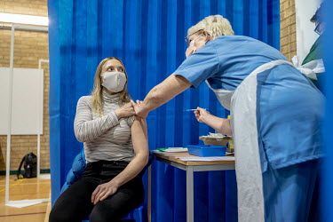 Katherine Carnegie, a junior doctor working in accident and emergency, receives the Pfizer/Biontec COVID-19 vaccination at the Cardiff and Vale Therapy Centre.