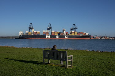 A woman watches a ship being loaded with containers at the port of Felixstowe. A combination of stockpiling for Brexit and the effects on trade of the COVID-19 crisis have meant that many ports are ov...