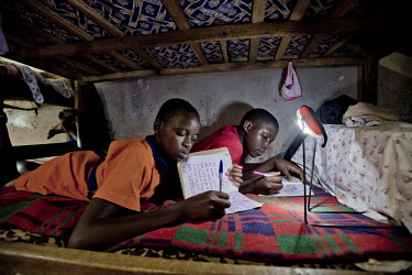In the girls' dormatory at the Kirugaluga Baptist Primary School, every evening, the matron (woman in charge of the dormatory) lights the room with solar lights.