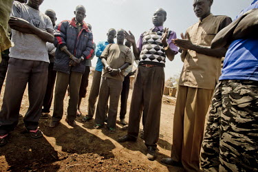 Pastor, Simon Garang, leads the prayers as a three week old baby, who died in the night at the Dzaipi health clinic, is buried in Olua South Sudanese refugees' settlement.