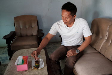 Joko Wiyono preparing to drink a potion containing the blood, bile and spinal cord of a spitting cobra at the home of Samijan, a traditional healer, in Kediri. Wiyono says he is a regular. The potion...
