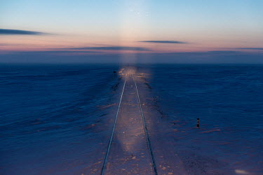 Tracks of the Obskaya-Bovanenkovo railway line are illuminated by the locomotive's lights as it travels over the frozen tundra. It is the northernmost railway in the world, built on the permafrost of...