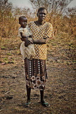Adhieu Akol, who is partially sighted, holding her granddaughter Adut Ajak, whose mother is dead and her father's whereabouts are unknown, at the Nyumanzi settlement.