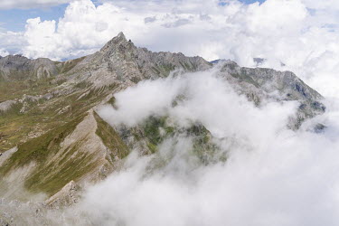 The foggy peak of Bric Bouchet, 2998 m high, in Le Queyras National Park in the French Alps. This region on the French-Italian border often showcases the meteorological phenomenon called La Nebbia, a...