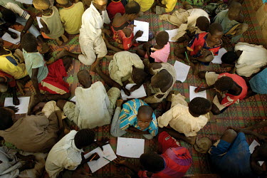 Boys drawing pictures in the Koubigou camp for internally displaced persons.