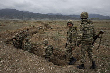 Azerbaijani soldiers walk down into a trench during a training exercise on a base near the frontline somewhere in central Azerbaijan. Many of the young men had already been fighting on the frontline a...