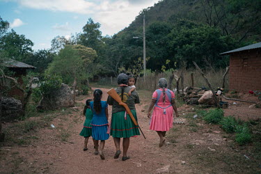 Adela Virgeno, wife of Bernardino Sanchez (founder of CRAC-PF), walks home holding her younger daughter along her family after a Regional Coordinator of Community Authorities (CRAC-PF) police force gu...