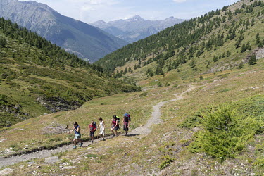 Hikers walk a trail towards Col Lacroix in Le Queyras National Park in the French Alps.
