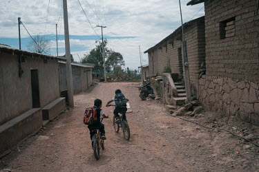 Angel (6) and a friend ride their bikes home from school in Ayahualtempa where murderous attacks by the drug cartel Los Ardillos have left residents of the town, and near by communities, isolated and...