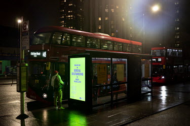 A bus stop where a poster reminds people to 'maintain social distancing' on public transport.