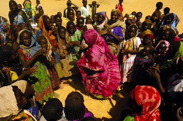A teacher (purple dress) dancing and singing with pupils in the Koubigou camp for internally displaced persons. The teacher herself is an IDP who has been trained to teach both the host population and...