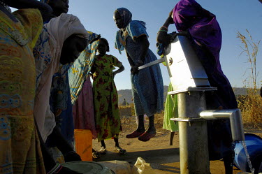 Children pump water from a communal well in the Gourounkoum camp for internally displaced persons.