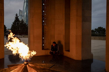 A man squats beside the eternal flame during a visit to the monument to pay his respects to those who have died in the various Nagorno Karabakh wars with Armenia.